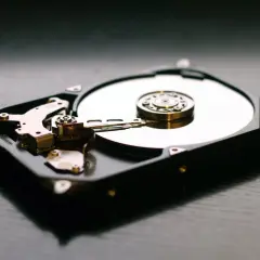 Wnętrze dysku HDD, z widocznymi talerzami i głowicami, kontrastuje z nowoczesnymi dyskami SSD.