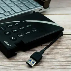 Dysk zewnętrzny USB 3.0 i fragment laptopa. Pomyśl o tym jak o sposobie, jak udostępnić internet z iPhone na komputer przez USB.