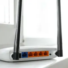 Biały router z dwiema antenkami, pokazujący porty LAN. To urządzenie, które pozwala na połączenie z internetem, czyli co to jest modem.