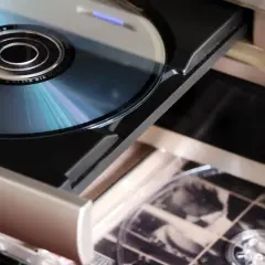 Wysunięta tacka odtwarzacza z płytą CD, klasyczne nośniki optyczne, gotowe do odtworzenia muzyki.
