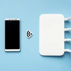Smartfon i router Wi-Fi obok symbolu sieci. Dowiedz się, jak udostępnić internet z telefonu.
