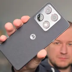 Mężczyzna prezentuje smartfon Motorola z charakterystycznym logo i modułem aparatów.