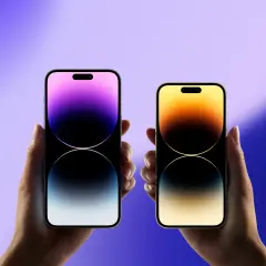 Dwie dłonie trzymają nowe iPhone'y, prezentując ich ekrany z gradientem kolorów. Czekamy na premierę, kiedy wyszedł iPhone 15.