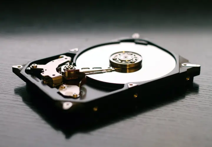 Wnętrze dysku HDD, z widocznymi talerzami i głowicami, kontrastuje z nowoczesnymi dyskami SSD.