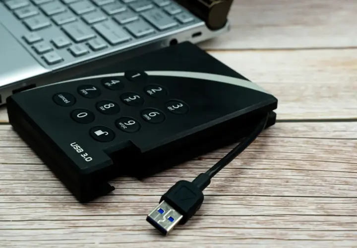 Dysk zewnętrzny USB 3.0 i fragment laptopa. Pomyśl o tym jak o sposobie, jak udostępnić internet z iPhone na komputer przez USB.