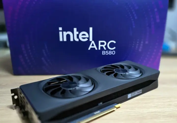 Karta graficzna Intel Arc A580 z dwoma wentylatorami na tle fioletowego pudełka z logo Intel Arc.