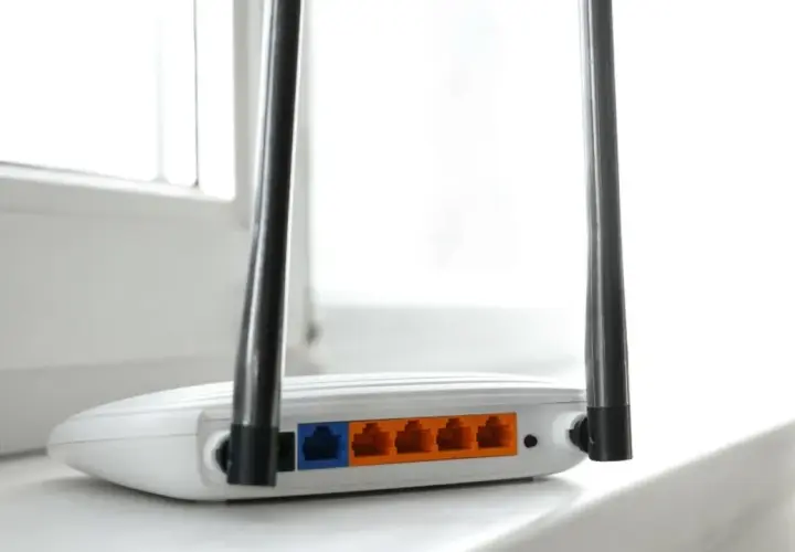 Biały router z dwiema antenkami, pokazujący porty LAN. To urządzenie, które pozwala na połączenie z internetem, czyli co to jest modem.