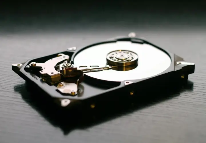 Wnętrze dysku twardego, widoczna błyszcząca płyta i ramię odczytujące. Idealny **hd tune** dla miłośników technologii.