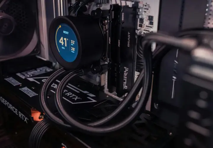 Chłodzenie NZXT z okrągłym, **resizable bar** wyświetlającym temperatury CPU, GPU i cieczy. Widać też kartę GeForce RTX i moduły RAM.