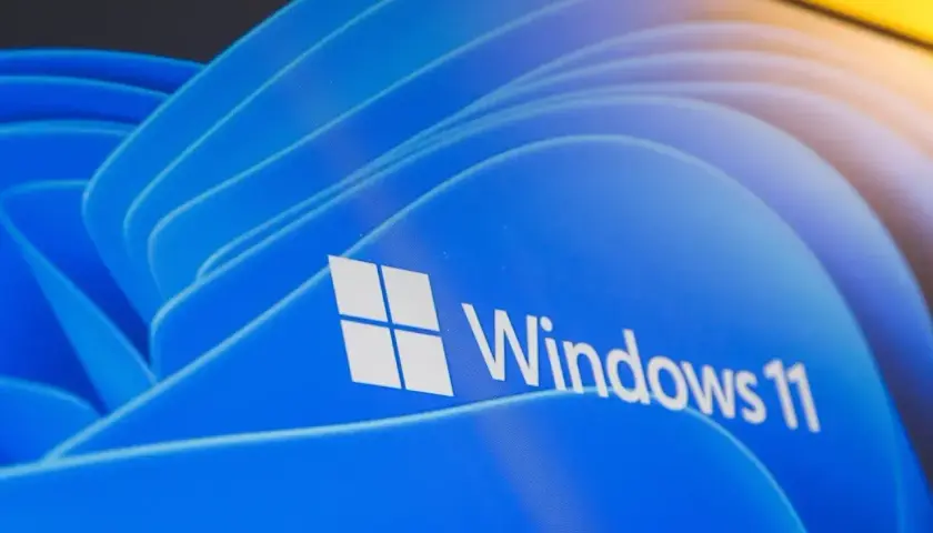 Logo Windows 11 na niebieskim tle. Dowiedz się, jak zainstalować Windows 11 na starym komputerze, nawet jeśli nie spełnia wymagań.