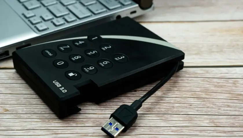 Dysk zewnętrzny USB 3.0 i fragment laptopa. Pomyśl o tym jak o sposobie, jak udostępnić internet z iPhone na komputer przez USB.