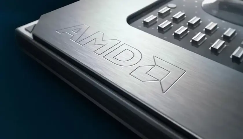 Metalowa powierzchnia procesora AMD z wygrawerowanym logo. To potężny Ryzen 9 6900HX, serce nowoczesnych laptopów gamingowych.
