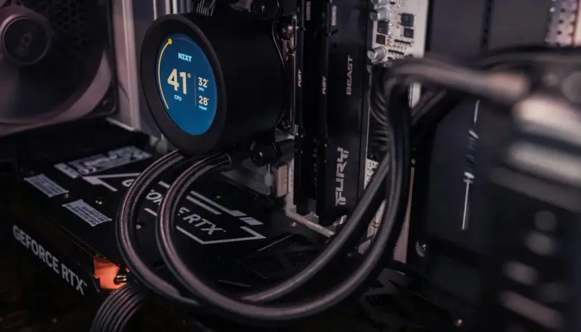 Chłodzenie NZXT z okrągłym, **resizable bar** wyświetlającym temperatury CPU, GPU i cieczy. Widać też kartę GeForce RTX i moduły RAM.