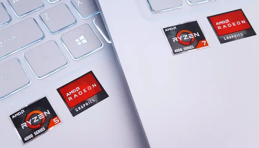 Naklejki AMD Ryzen 5 i Ryzen 7 z grafiką Radeon Graphics na białej klawiaturze laptopa.