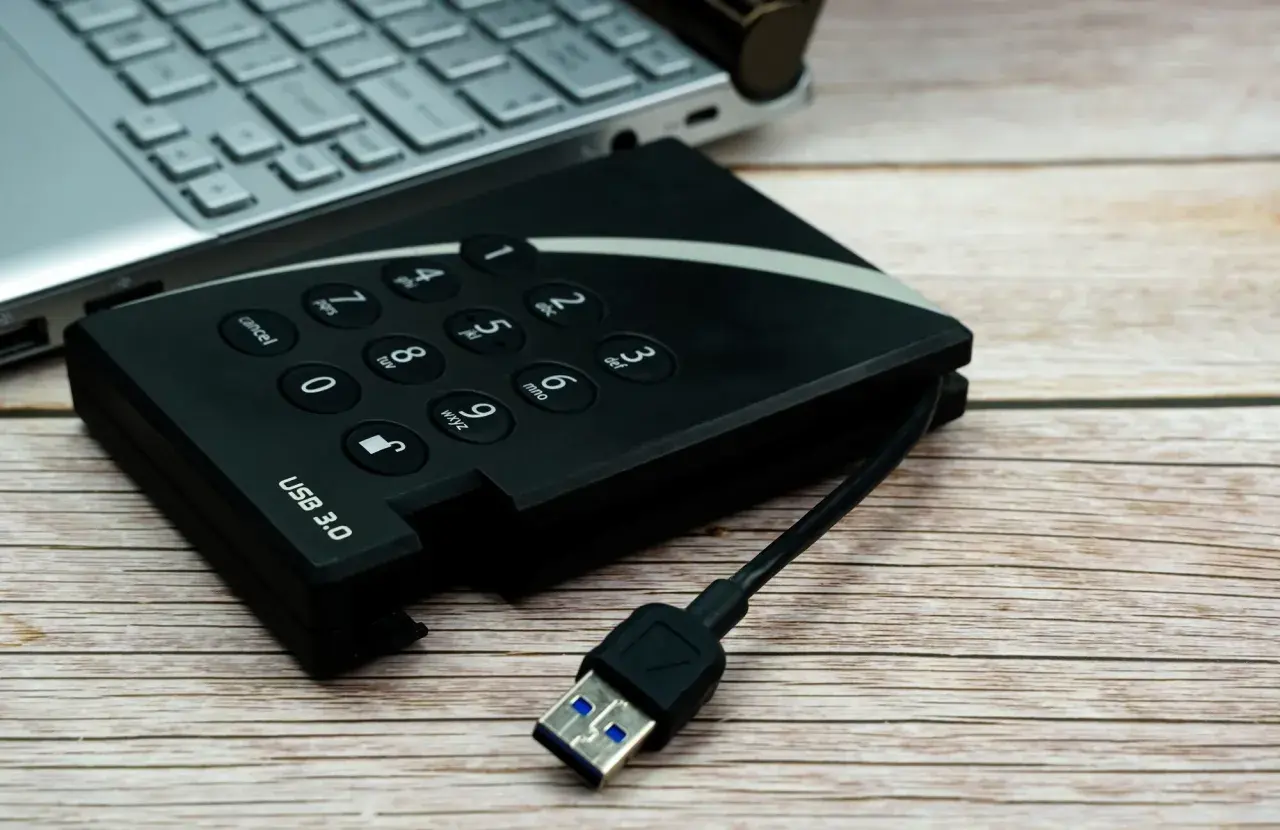 Dysk zewnętrzny USB 3.0 i fragment laptopa. Pomyśl o tym jak o sposobie, jak udostępnić internet z iPhone na komputer przez USB.