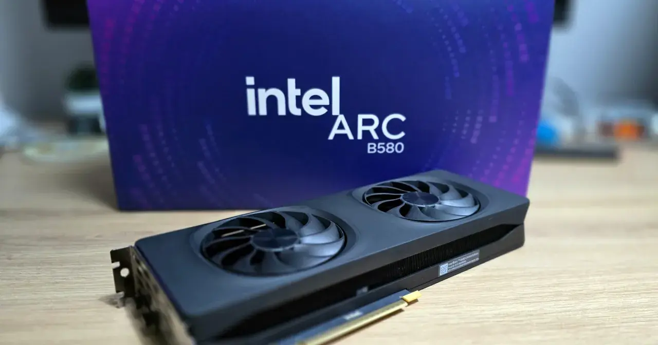 Karta graficzna Intel Arc A580 z dwoma wentylatorami na tle fioletowego pudełka z logo Intel Arc.