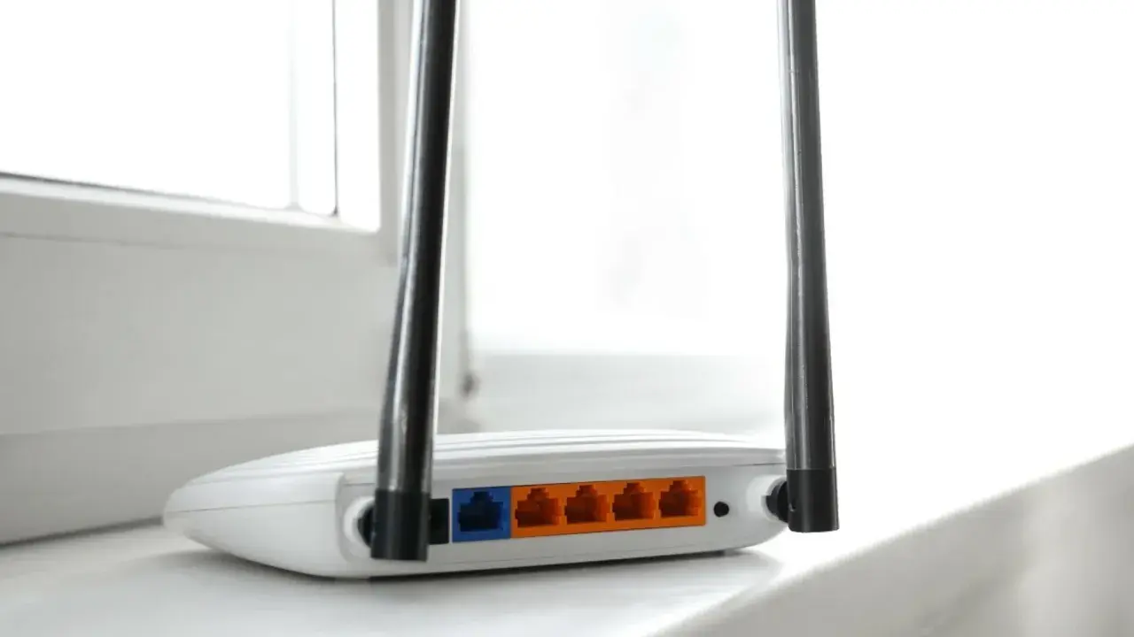 Biały router z dwiema antenkami, pokazujący porty LAN. To urządzenie, które pozwala na połączenie z internetem, czyli co to jest modem.