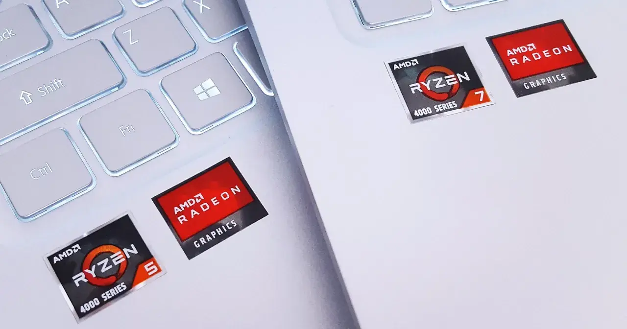 Naklejki AMD Ryzen 5 i Ryzen 7 z grafiką Radeon Graphics na białej klawiaturze laptopa.