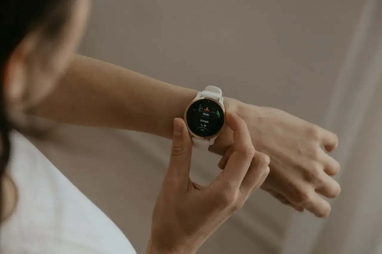 Kobieta sprawdza na swoim zegarku Garmin Forerunner 570 gotowość do treningu.