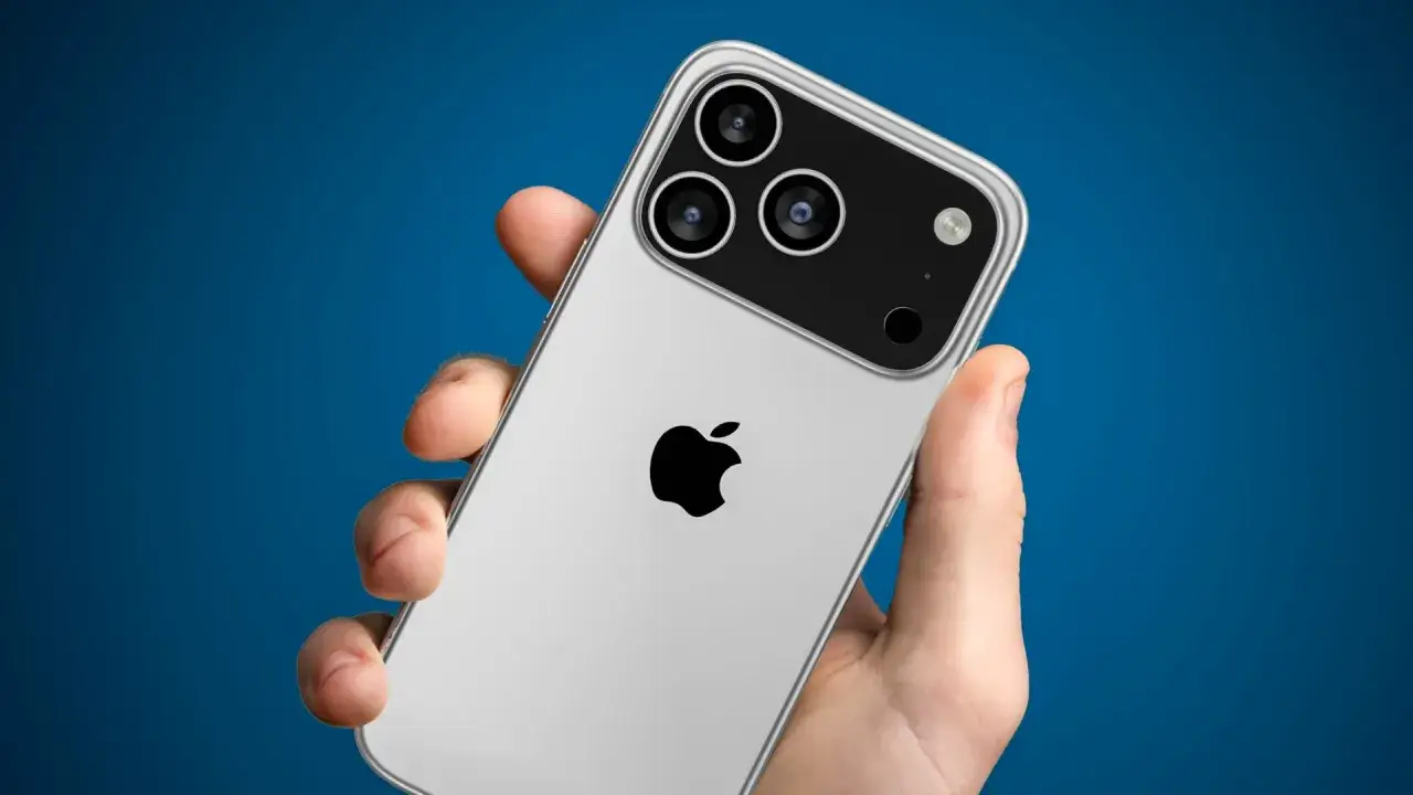 Dłoń trzyma srebrny telefon z potrójnym aparatem, logo Apple i napisem ip 17e.
