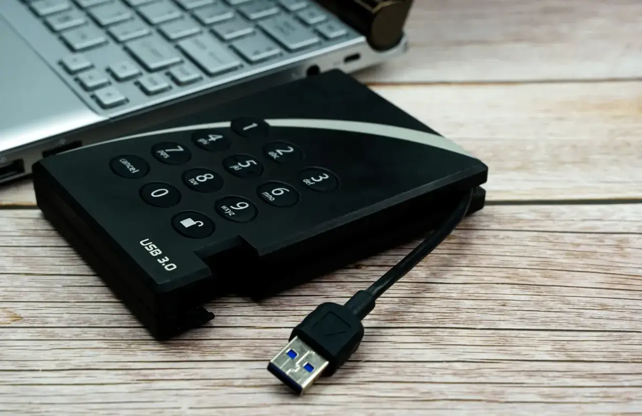 Dysk zewnętrzny USB 3.0 i fragment laptopa. Pomyśl o tym jak o sposobie, jak udostępnić internet z iPhone na komputer przez USB.