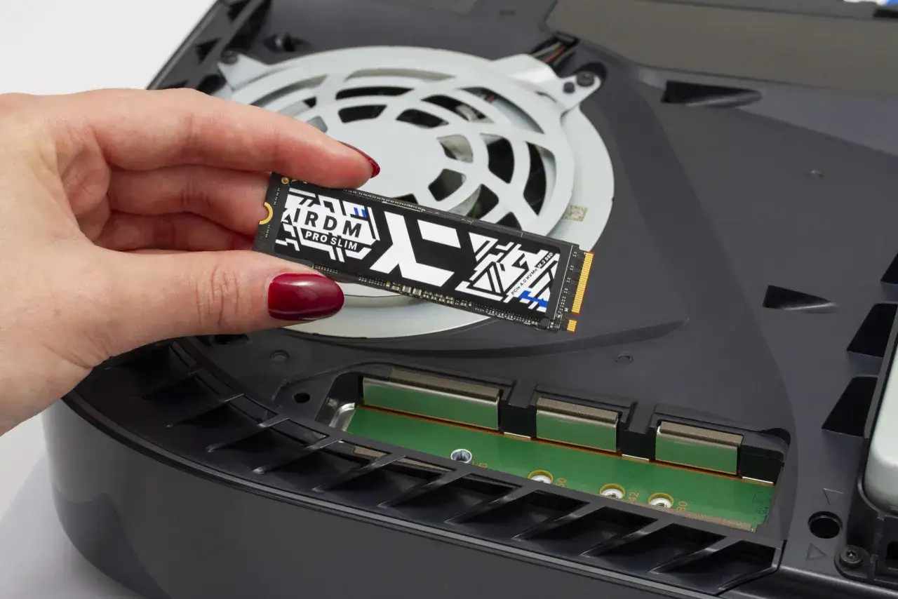 Dłoń trzyma dysk SSD, kt&oacute;ry będzie służył jako pamięć do PS5. Montaż rozszerzenia pamięci jest prosty.